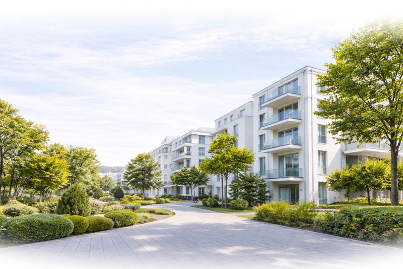 Moderne Wohnanlage mit begrünten Wegen und hellen Mehrfamilienhäusern